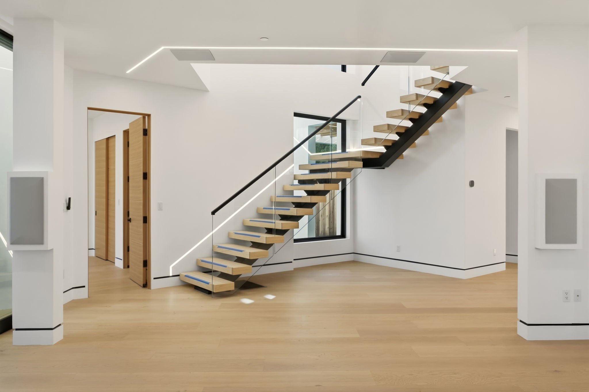 Floating oak staircase with glass and metal railing